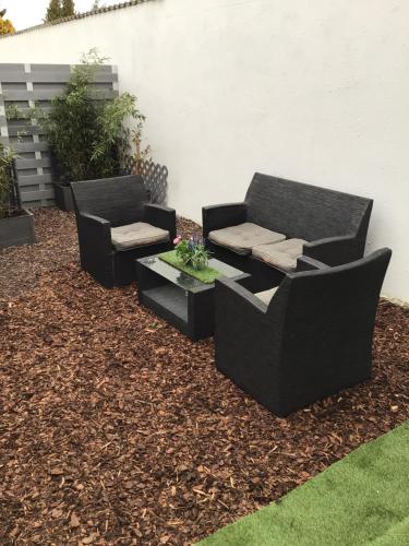 two black chairs and a table in a yard at Pension Claudia in Vösendorf
