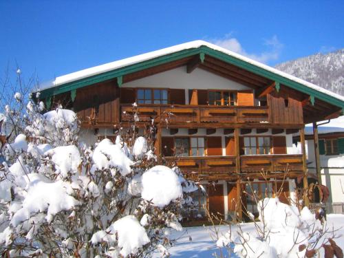 a log cabin in the snow with snow covered trees at Landhotel Maiergschwendt inkl Chiemgaukarte in Ruhpolding