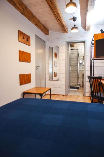 a bedroom with a blue bed and a table at CASA HINTZ Transilvania in Făgăraş