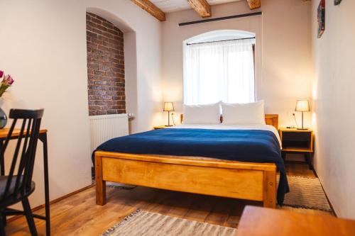 a bedroom with a bed with a blue blanket and a window at CASA HINTZ Transilvania in Făgăraş