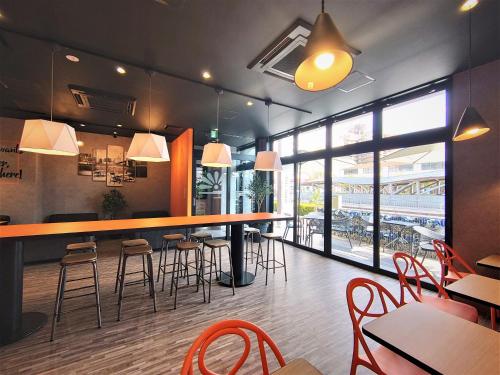 a restaurant with a bar with chairs and tables at Green Rich Hotel Matsue Station Across - Artificial hot spring Futamata Yunohana in Matsue