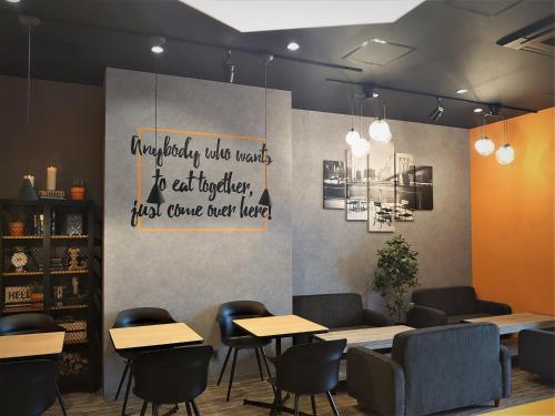 a restaurant with tables and chairs and a sign on the wall at Green Rich Hotel Matsue Station Across - Artificial hot spring Futamata Yunohana in Matsue