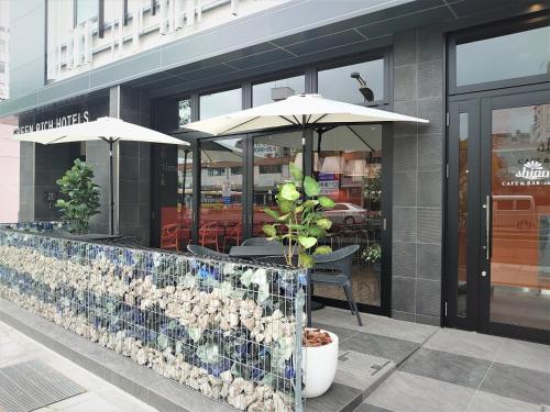 a restaurant with a table with an umbrella at Green Rich Hotel Matsue Station Across - Artificial hot spring Futamata Yunohana in Matsue