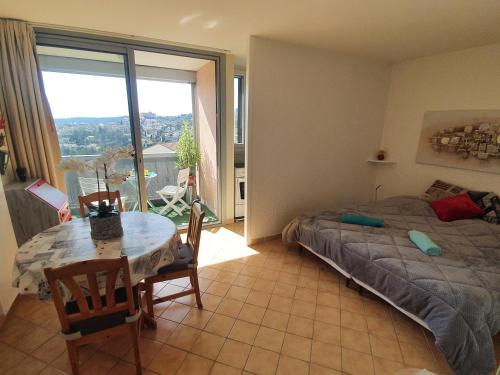 une chambre avec un lit, une table et une fenêtre dans l'établissement La vue du château - tout confort, à Gréoux-les-Bains