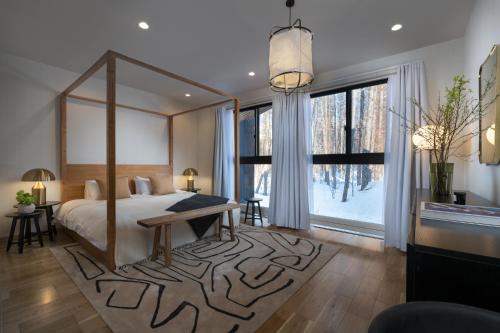 um quarto com uma cama grande e uma janela grande em Ginto Hirafu by H2 Life em Niseko