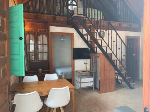 a dining room with a table and a staircase at Casa Rural Los Pepe Sancti Petri in Chiclana de la Frontera