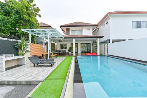 a swimming pool in the backyard of a house at 4BD Pool Villa Pattaya with Jacuzzi - Exquisite Pool Villa A in Pattaya South