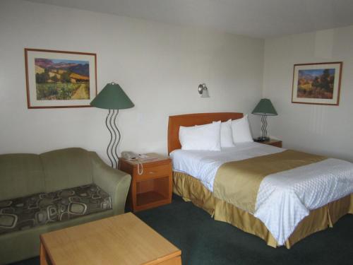 a hotel room with a bed and a couch at Ramada Merritt in Merritt
