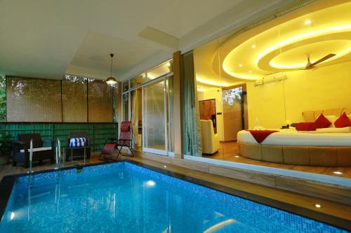 a hotel room with a pool and a bed at Kuruva Island Resort And Spa - By KABINI BREEZE in Mananthavady
