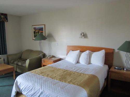 a hotel room with a bed and a couch at Ramada Merritt in Merritt