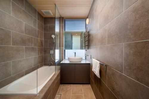 Un baño con bañera, lavabo y ducha. en Yotei Dream One, en Kutchan