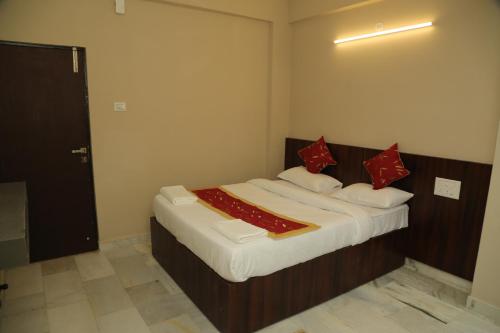 a bedroom with a large bed with red pillows at Soundarya Hotel in Bengaluru