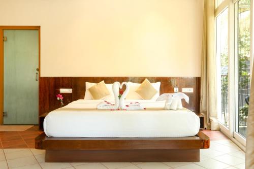 a bedroom with a bed with two stuffed animals on it at Kuruva Island Resort And Spa - By KABINI BREEZE in Mananthavady
