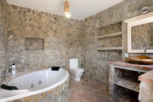 a bathroom with a tub and a toilet at Villa Africa in La Muela