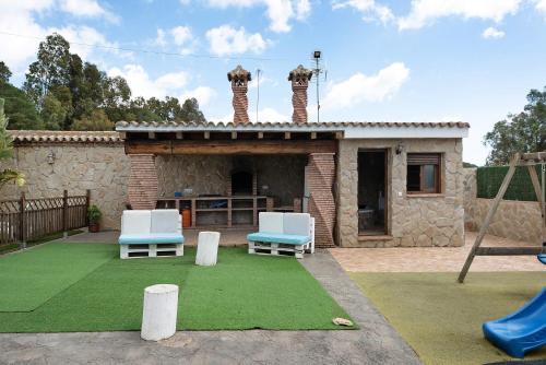 a backyard with two chairs and a playground at Villa Africa in La Muela