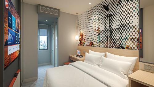 Go Hotels Plus Naga في نجا: غرفة نوم مع سرير أبيض كبير في غرفة