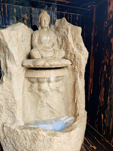 a statue of a buddha sitting on a rock at WhiteHouse Homestay by Oxystays Hospitality in Alibaug