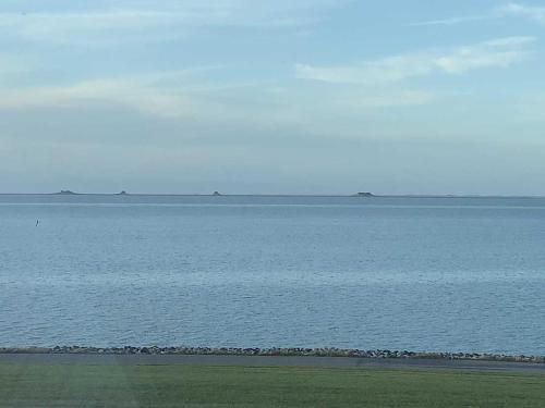 a large body of water with a group of islands in the distance at Ferienwohnung Frische Brise in Nordstrand