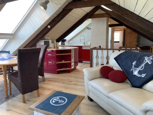 a living room with a couch and a kitchen at Ferienwohnung Frische Brise in Nordstrand