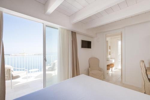 a white bedroom with a view of the ocean at Tra Cielo e Mare in Vieste