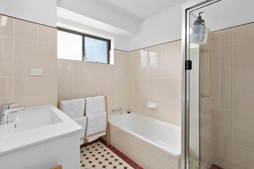 y baño con bañera, lavamanos y ducha. en Beachwood at Margate Beach, en Redcliffe