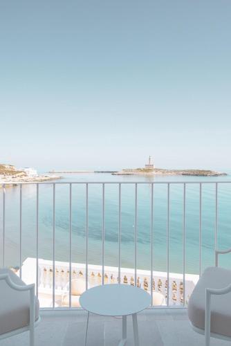 a view of the beach from a balcony with chairs and tables at Tra Cielo e Mare in Vieste