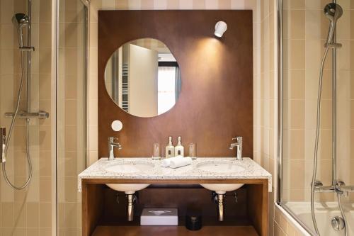 a bathroom with two sinks and a mirror and a shower at Hôtel Rosalie in Paris