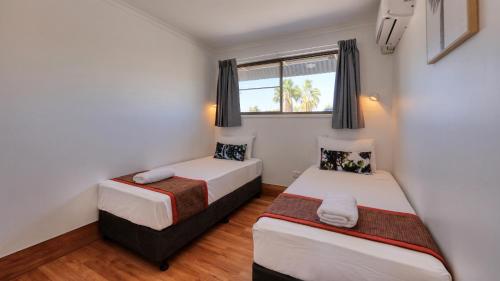 a bedroom with two beds and a window at Bryants Motel Roma in Roma