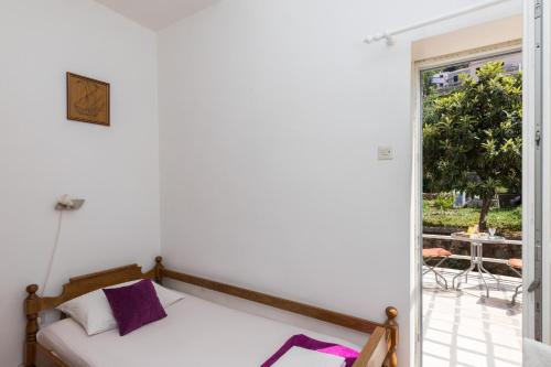 1 dormitorio con 1 cama y puerta que conduce a un patio en Guest House Bradas, en Dubrovnik