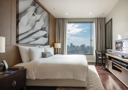 a bedroom with a large bed and a large window at 137 Pillars Residences Bangkok in Bangkok