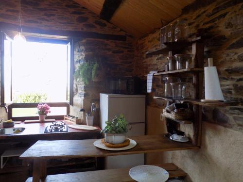 a kitchen with a table and a refrigerator and a window at Cabaña Bioxana in Molejón