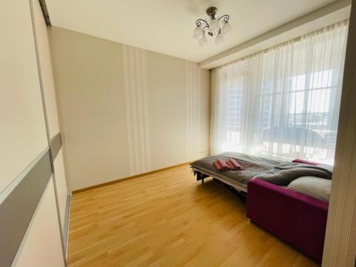 um quarto com uma cama num quarto com uma janela em Jaunā Teika Penthouse em Riga