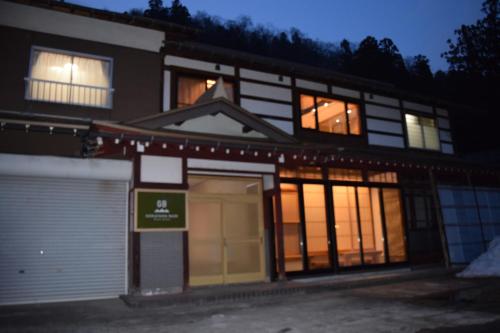 un edificio con muchas ventanas delante de él en GOKAYAMA BASE, en Nanto