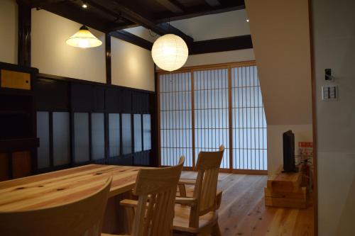 una sala da pranzo con tavolo e sedie in legno di GOKAYAMA BASE a Nanto