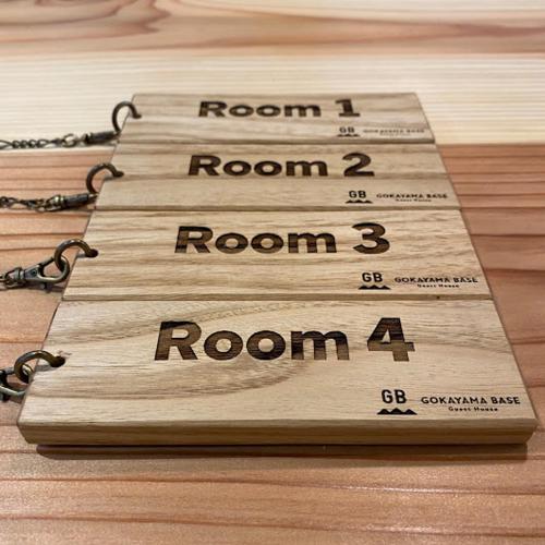 a row of wooden signs on a wooden table at GOKAYAMA BASE in Nanto