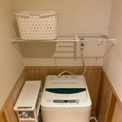 a kitchen with a washing machine and a basket at GOKAYAMA BASE in Nanto