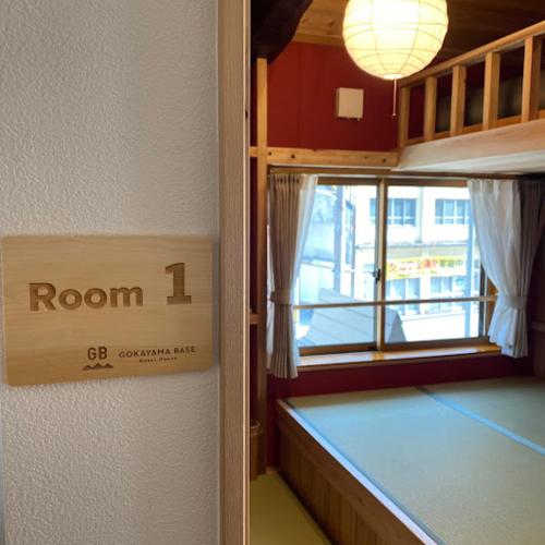a room with a room sign on the wall at GOKAYAMA BASE in Nanto