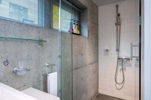 a bathroom with a glass shower and a sink at Yuki Uchi by H2 Life in Niseko