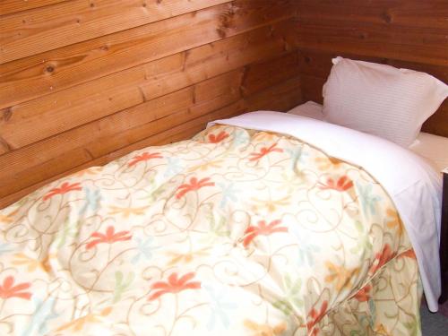 a bed in a room with a wooden wall at Minamitsuru-gun - Hotel / Vacation STAY 45535 in Yamanakako