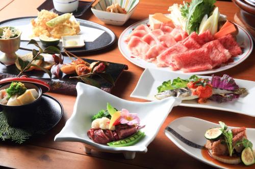 a wooden table with plates of food on it at Hanare no Yado Hanagokoro in Minamioguni