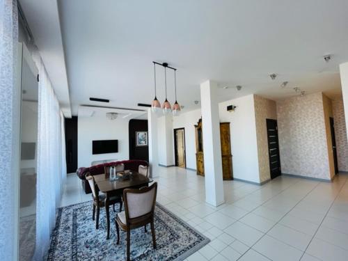 a living room with a table and chairs at Jaunā Teika Penthouse in Rīga