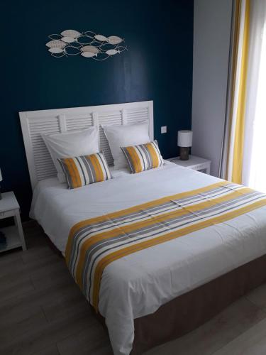 a bedroom with a large white bed with colorful pillows at Les Rives du Bassin in Le Teich