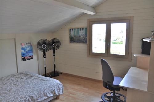 1 dormitorio con cama, escritorio y ventana en Villa avec piscine a Hendaye, en Hendaya