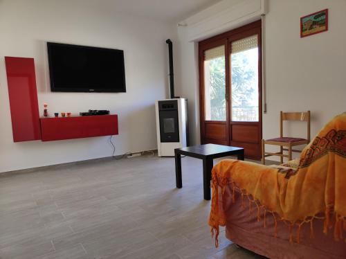a living room with a couch and a tv on the wall at CASA VACANZE My Way in Cavo