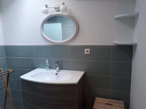 uma casa de banho com um lavatório e um espelho em Gite les Olivettes em Vailhan