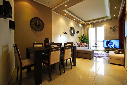 a dining room and living room with a table and chairs at kavala squareview in Kavala