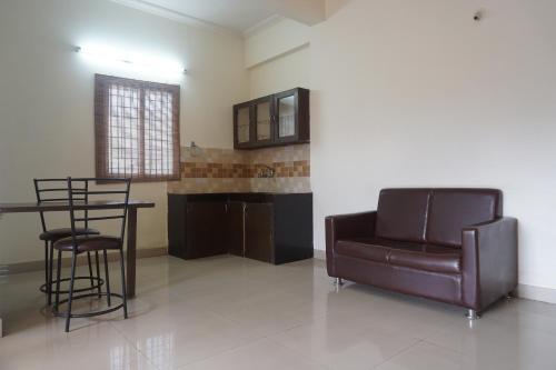 a living room with a couch and a table and chairs at Sorrento Homes in Pune