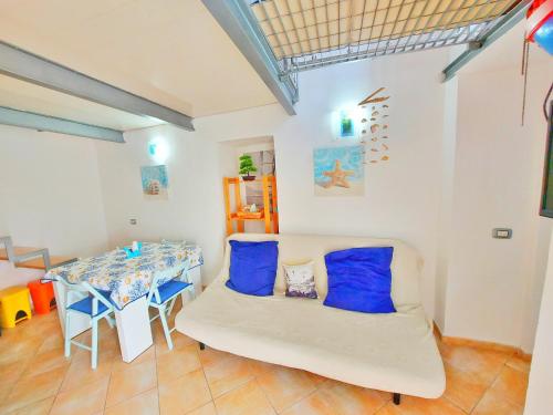 a room with a couch and a table with blue pillows at Monolocale Azzurro Procida in Procida