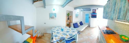 Zimmer mit einem Tisch und einem Esszimmer in der Unterkunft Monolocale Azzurro Procida in Procida