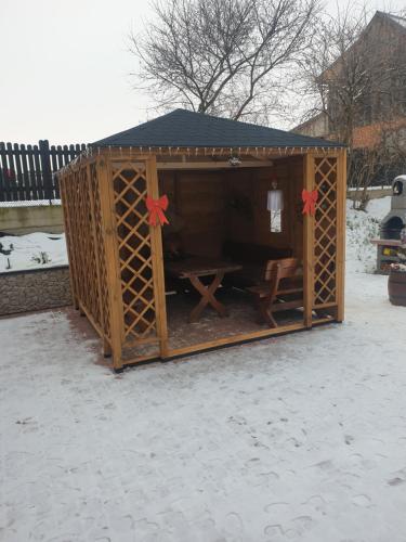 a wooden shed with a table and red bows at Apartamenty u Baców in Ostrowsko